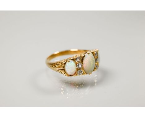 An antique three-stone opal and diamond ring, the graduated opals with three small diamonds between, yellow gold set stamped 