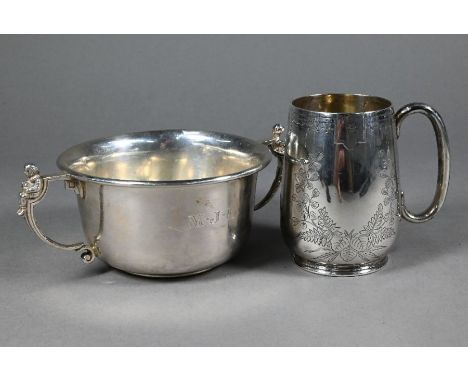 A Victorian foliate-engraved silver Christening mug, London 1885 to/w a porringer, the twin handles cast with the figures of 