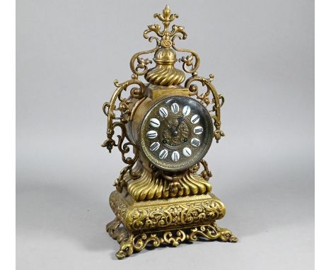 A Rococco style ornate cast brass 8-day mantel clock, the drum movement with white enamelled porcelain tablet roman numeral c