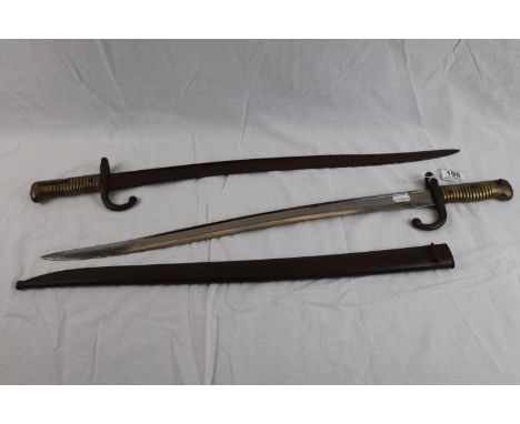 Two French sabre bayonets, one complete with scabbard. Both bayonets have various proof marks.