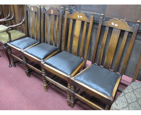A Set of 1920's Oak Dining Chairs, shaped top rail, drop in seats, on bobbin and block supports, central stretcher. (4)