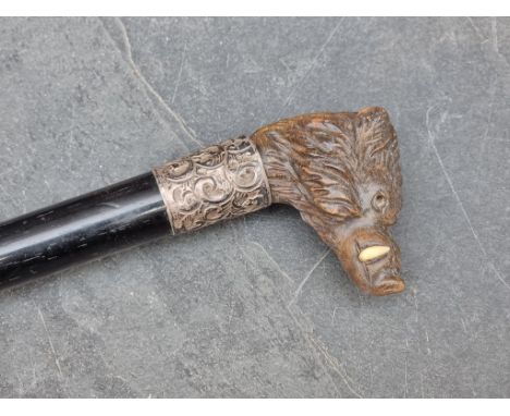 A Victorian ebony, carved wood and silver mounted novelty boar's head cane, Birmingham 1898, with bone tusks, (lacking one tu