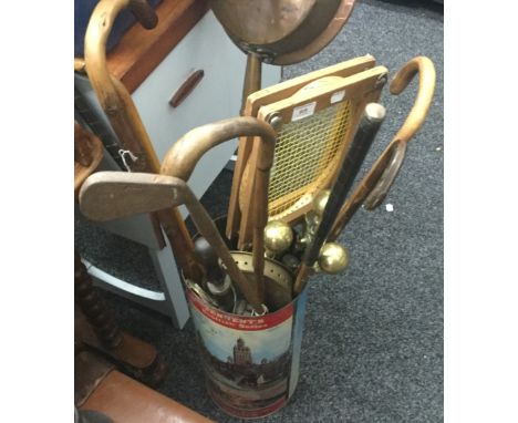 A stick stand containing various items, including golf clubs, fire irons, etc.
