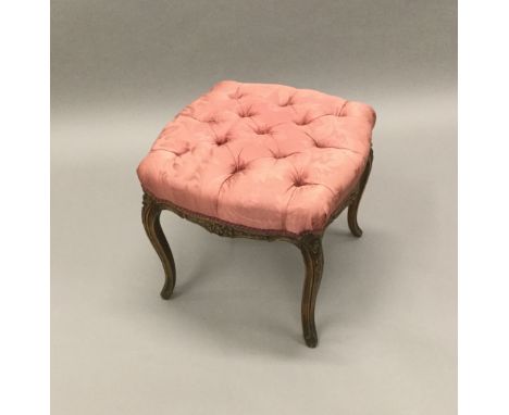 A carved beech stool, the serpentine seat button upholstered, standing on slender cabriole legs.  51 cm wide. 