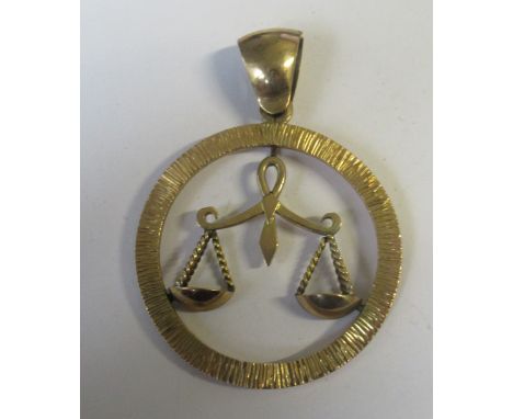A 9ct Libra pendant, designed as a textured hoops containing weighing scales, stamped 9ct, weight 13.0g&nbsp;