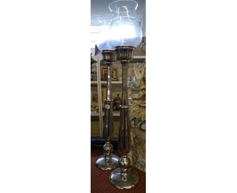 A pair of silvered metal storm lantern candlesticks.
