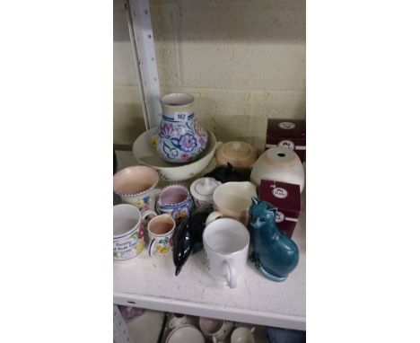 A large collection of various Poole Pottery items including a pedestal bowl, Art Deco ribbed lamp base, two blue glazed dolph