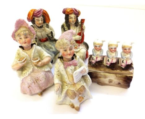 A pair of 19th century miniature Bisque porcelain figures of a Girl and Boy seated in period costume with nodding heads toget