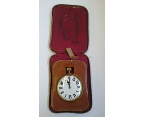 A large open faced eight day white enamel faced travelling clock in leather fitted case.