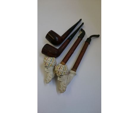 A Meerschaum clay pipe modelled as an Arab's head by Jacob together with another and two English pipes.