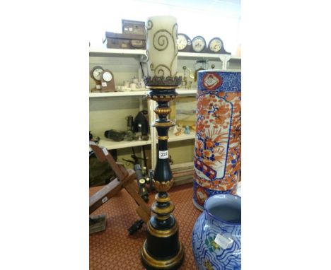 A black and gold painted wooden pricket candlestick.