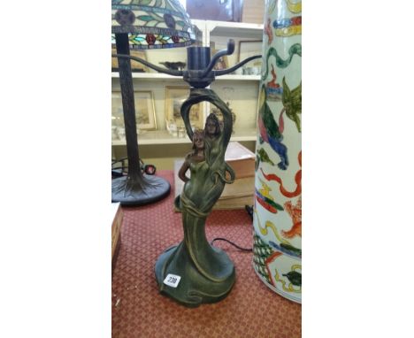 An Art Nouveau style metal lamp base modelled as two female figures.