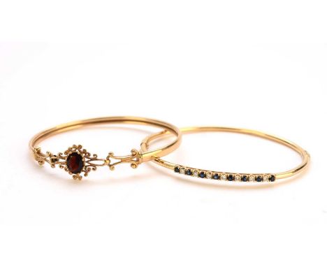 A 9ct gold garnet bangle, with integral hook clasp, together with a diamond and sapphire set bangle, stamped '375 9ct', total