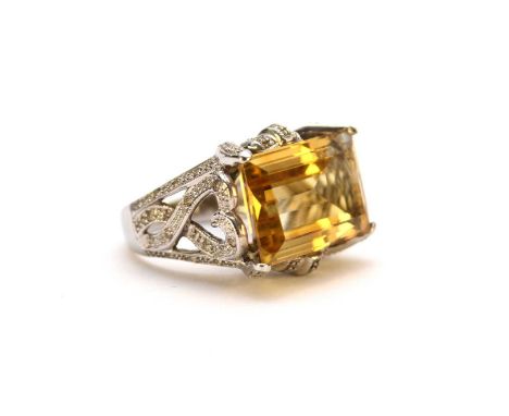 A large citrine and diamond dress ring, the rectangular faceted citrine claw set to decorative diamond set mount with pierced