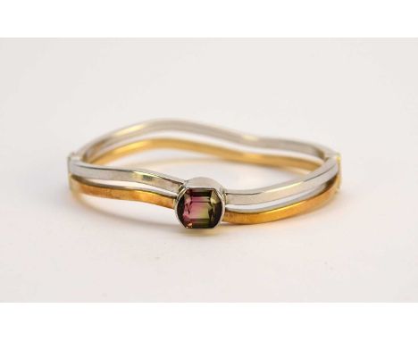 An Italian Watermelon tourmaline set bangle, designed as a single faceted watermelon tourmaline set in white metal and mounte
