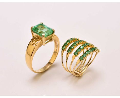 A single stone untested emerald ring, stamped ‘750’, ring size T 1/2, together with an emerald set four band ring, stamped '7