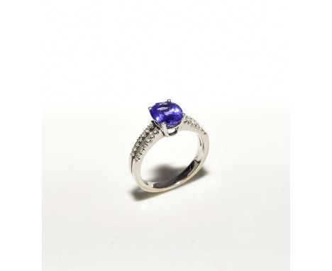 An 18ct white gold tanzanite and diamond ring, designed as a single oval mixed cut sapphire claw set in white gold and mounte