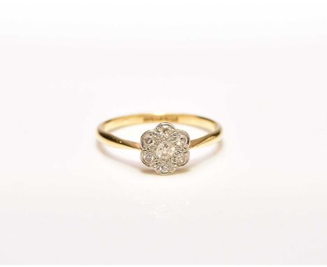 An early 20th century floral diamond cluster ring, the faceted round diamonds claw set in white metal to yellow metal shank, 