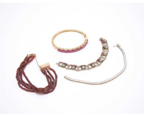 A multi-strand garnet bead bracelet with yellow metal clasp, together with a silver gilt untested ruby set hinged bangle, an 