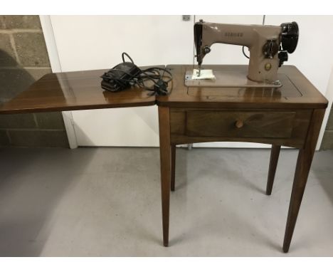 A vintage dark wood cased table treadle singer sewing machine together foot pedal &amp; accessories.Treadle converts to a tab