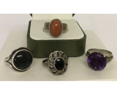 4 silver and white metal stone set dress rings.Comprising: a large round cut amethyst solitaire, modern design set with round