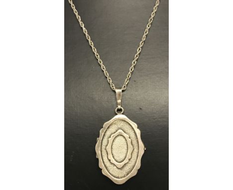 A vintage silver oval locket with scallop edge detail.On a 24 inch silver rope chain.Pendnat approx3.5cm x 2.5cm.