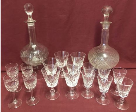 2 vintage glass decanters with a collection of liqueur, sherry and dessert wine crystal glasses.