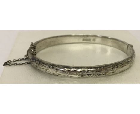 A vintage silver half engraved bangle complete with safety chain.Hallmarked Birmingham 1973.Total weight approx. 9.9g