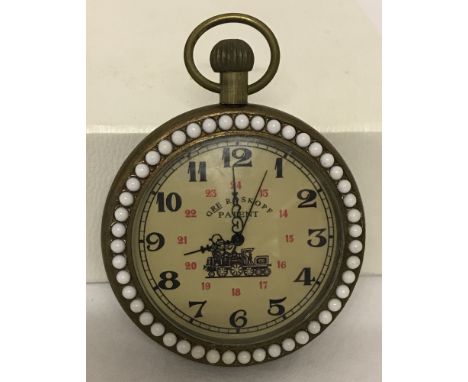 A brass cased pocket watch with beaded detail to surround front and back.Watch face approx. 4.5cm diameter.