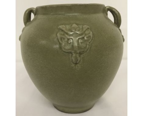 A 2 handled green glaze ceramic vase with details in relief front and back.Approx. 13cm tall.