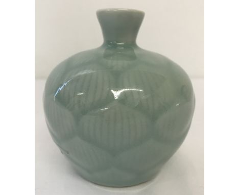 A small Chinese ceramic vase of bulbous form. Duck egg blue glaze with lotus flower petal detail.Printed signature to base.Ap