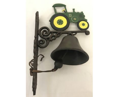 A painted cast iron, wall hanging garden bell with tractor detail.Approx. 38cm tall.