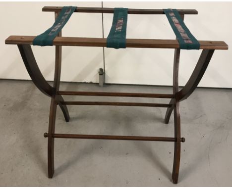 A vintage wooden suitcase stand, with green and red webbing.Approx. H 54 x W57 x D37cm.