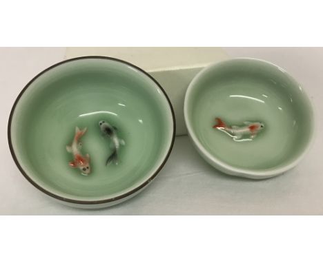 2 small ceramic Japanese bowls with fish detail to inner bowl, in pale green glaze.Largest approx. 3.5cm tall x 7.5cm diamete