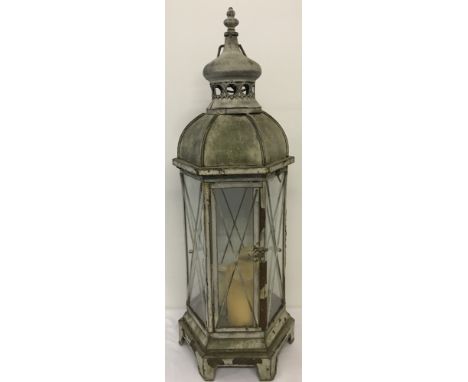 A metal and glass Moroccan style garden lantern with carry handle.Approx. 75cm tall.