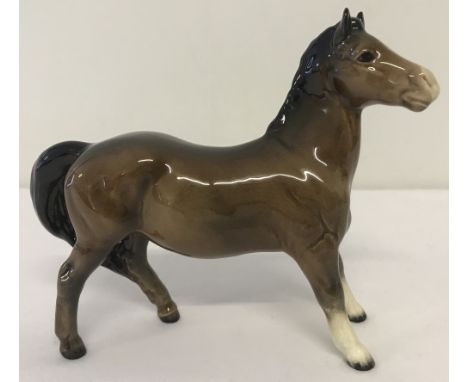 A Beswick ceramic Pony figurine (Girl's Pony) #1483, in brown colourway.With gloss finish and oval shaped back stamp. Designe