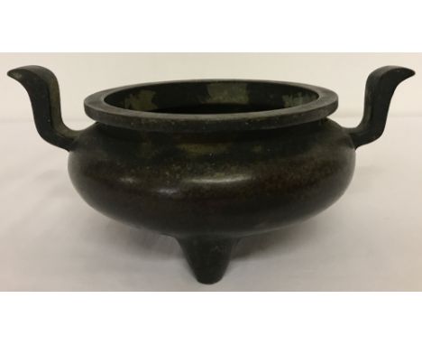 A large Chinese 2 handled censer with curved handles, raised on tripod feet.Approx. 8.5cm tall x 13.5cm diameter.