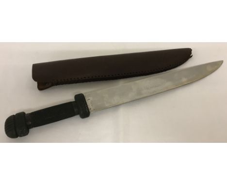 A machete style steel bladed knife.With a shagreen style handle and 34cm blade.  In a leather sheath.Approx. 50cm long.