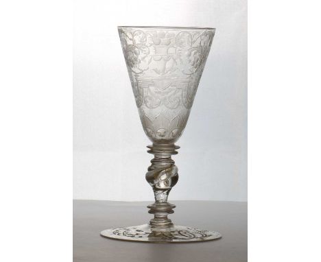 An engraved glass goblet,first half 18th century, probably Bohemian, with an engraved funnel bowl, with stylised figures and 