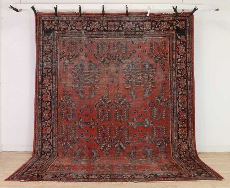  A North West Persian rug,early to mid 20th century, possibly Heriz, with spaced foliate motifs to a red field, and navy bord