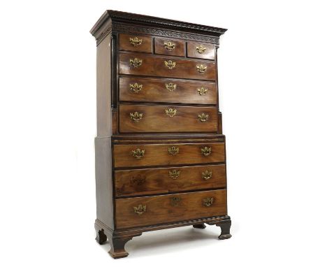 A George III mahogany chest on chest,blind fret frieze, column sides and brushing slide, cut brass plate handles, on ogee bra