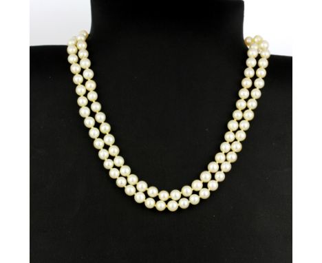 A double strand cultured pearl necklace with a 9ct yellow gold clasp set with a large oval cut sapphire, surrounded by seed p