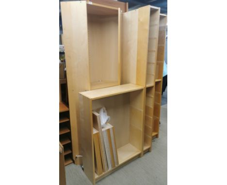 A large, extensive light wood wall shelving unit, currently disassembled.