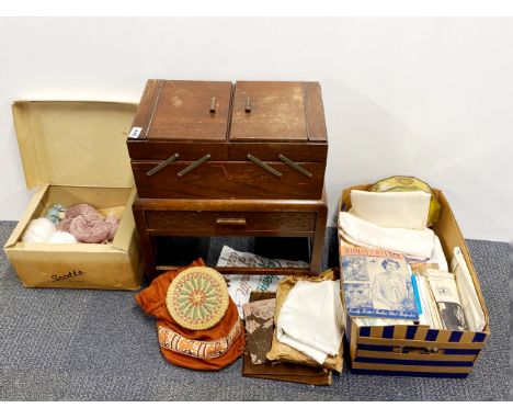 A vintage oak work box with a quantity of fabrics and other items.