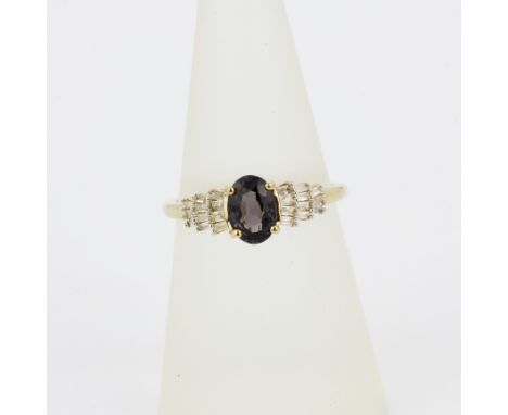 A hallmarked 9ct yellow gold ring set with an oval cut mystic topaz and baguette cut diamond shoulders, (M.5).