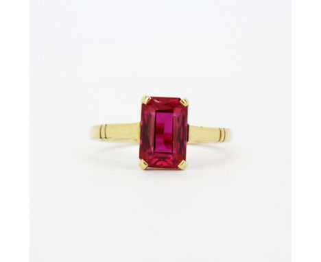 A 9ct yellow gold solitaire ring set with an emerald cut synthetic ruby, (N).