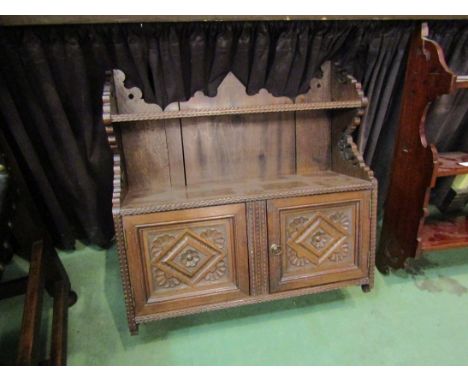 A carved wall hanging, two door cupboard with upper shelf, 62cm wide x 62cm wide