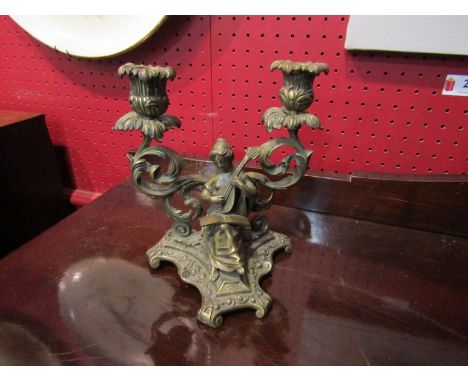 A brass twin sconce candlestick with lady playing musical instrument, 20cm tall