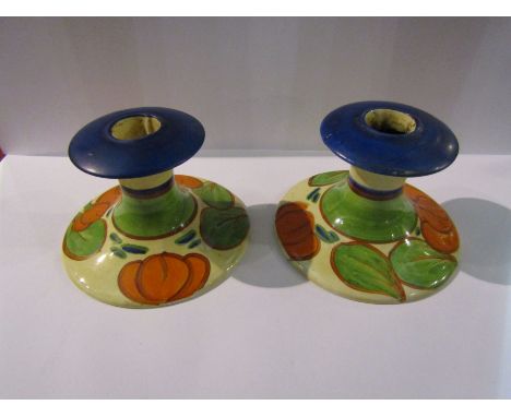 A pair of Clarice Cliff candlesticks in the "Orange Lily" pattern, both hairlined and chipped, 8cm tall
