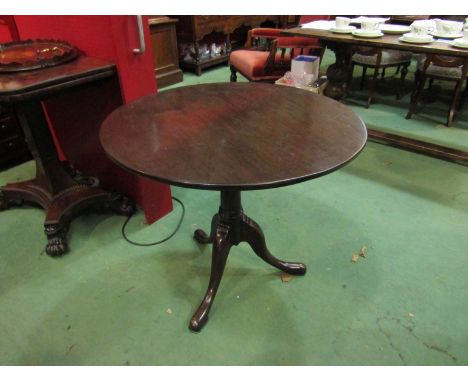 A George III mahogany revolving circular tilt top wine table on a cannon barrel column and tripod base, 79cm diameter x 68cm 